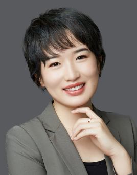 Professional woman smiling and posing confidently in a business attire.