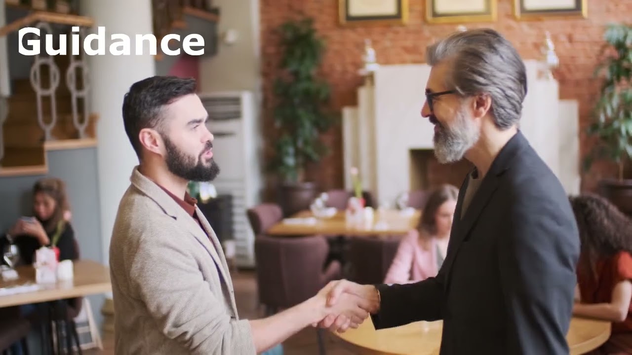 Two professionals shaking hands in a restaurant, engaged in a business discussion.