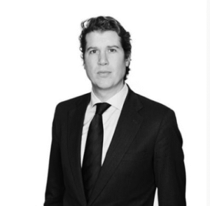 Attorney in a suit looking confidently at the camera against a neutral background.