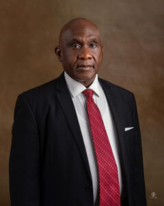 Lawyer in formal attire with a red tie, posing against a neutral background.
