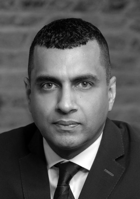 Lawyer in a suit with a serious expression, posing against a textured background.