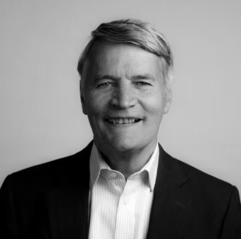 Lawyer with short hair and a confident smile, wearing a suit, against a plain background.