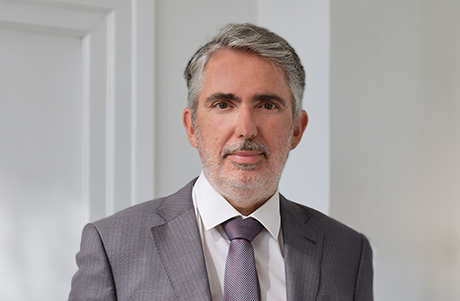 Attorney in a suit standing confidently, with a neutral background, conveying professionalism and legal expertise.