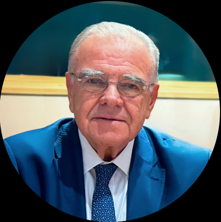 Senior lawyer in a blue suit, seated and engaged in discussion within a professional legal environment.