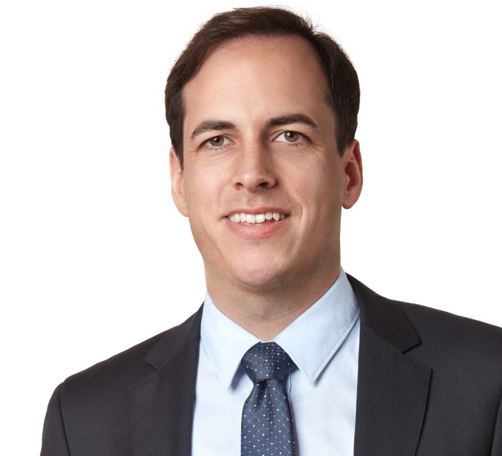 Smiling professional in a suit, suitable for a lawyer or attorney profile.