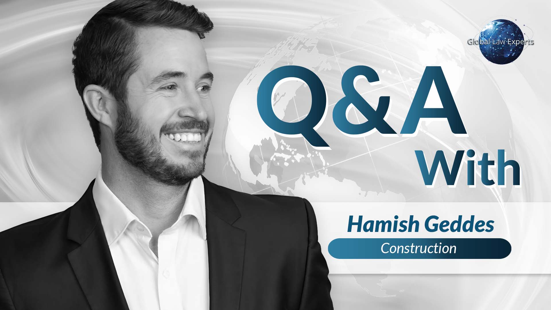 Professional smiling man in a suit with a world map background, part of a Q&A session on construction law.