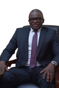 Lawyer seated in an office chair, wearing glasses and a suit, with a confident expression.