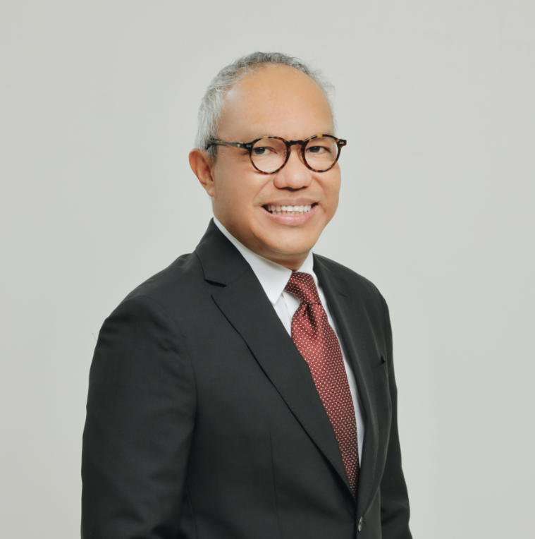 Attorney in formal suit smiling, posed against a neutral background, suitable for professional profile.