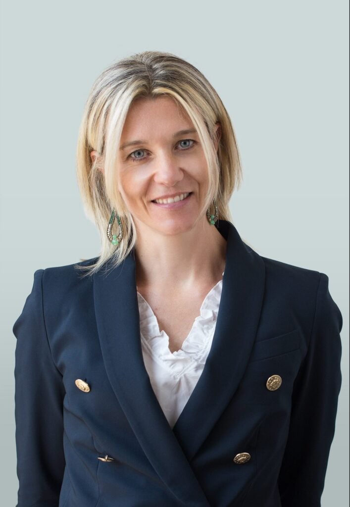 Attorney in professional attire smiling against a neutral background.