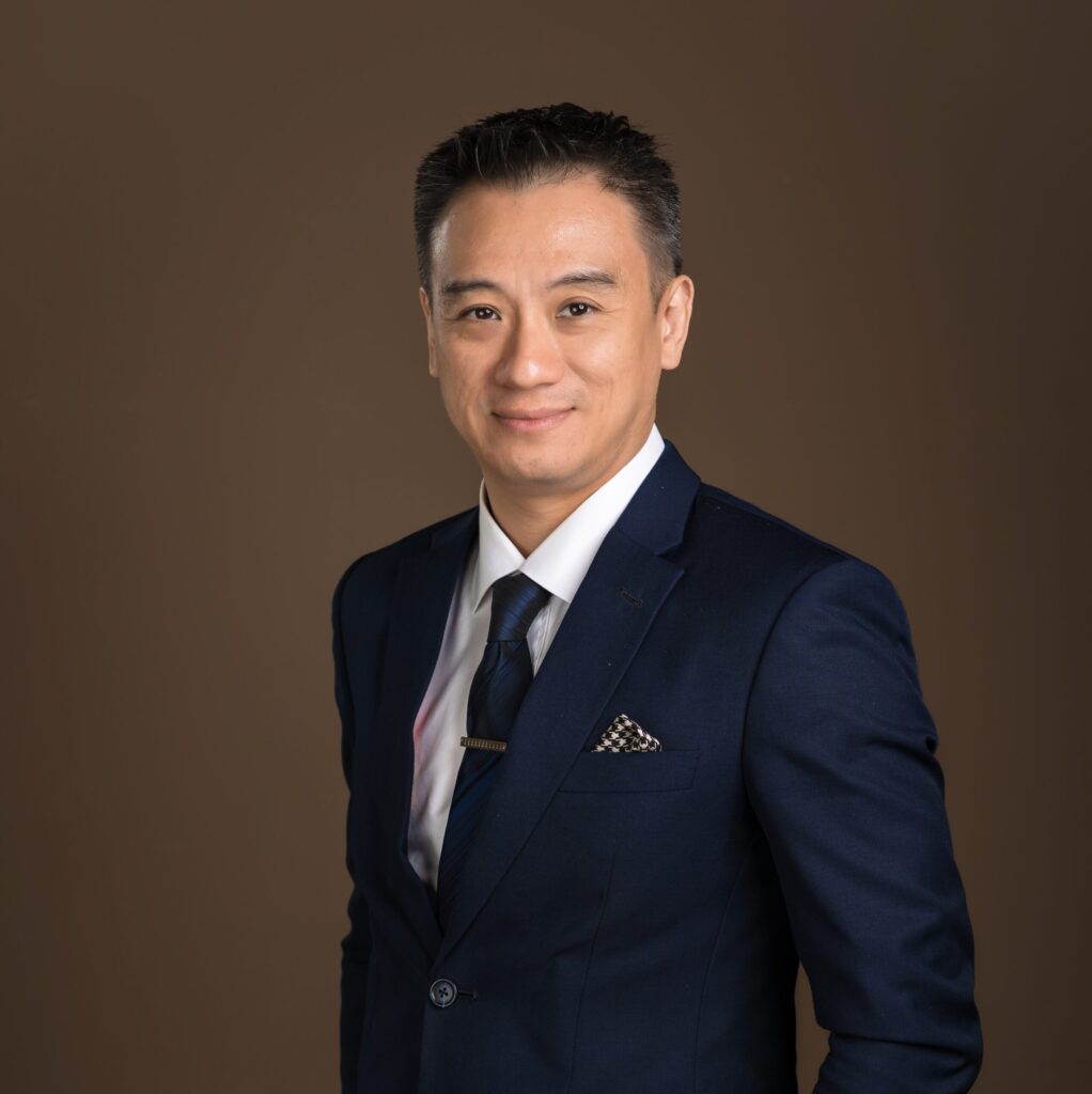 Lawyer in a dark suit with a patterned tie, posing confidently against a neutral background.