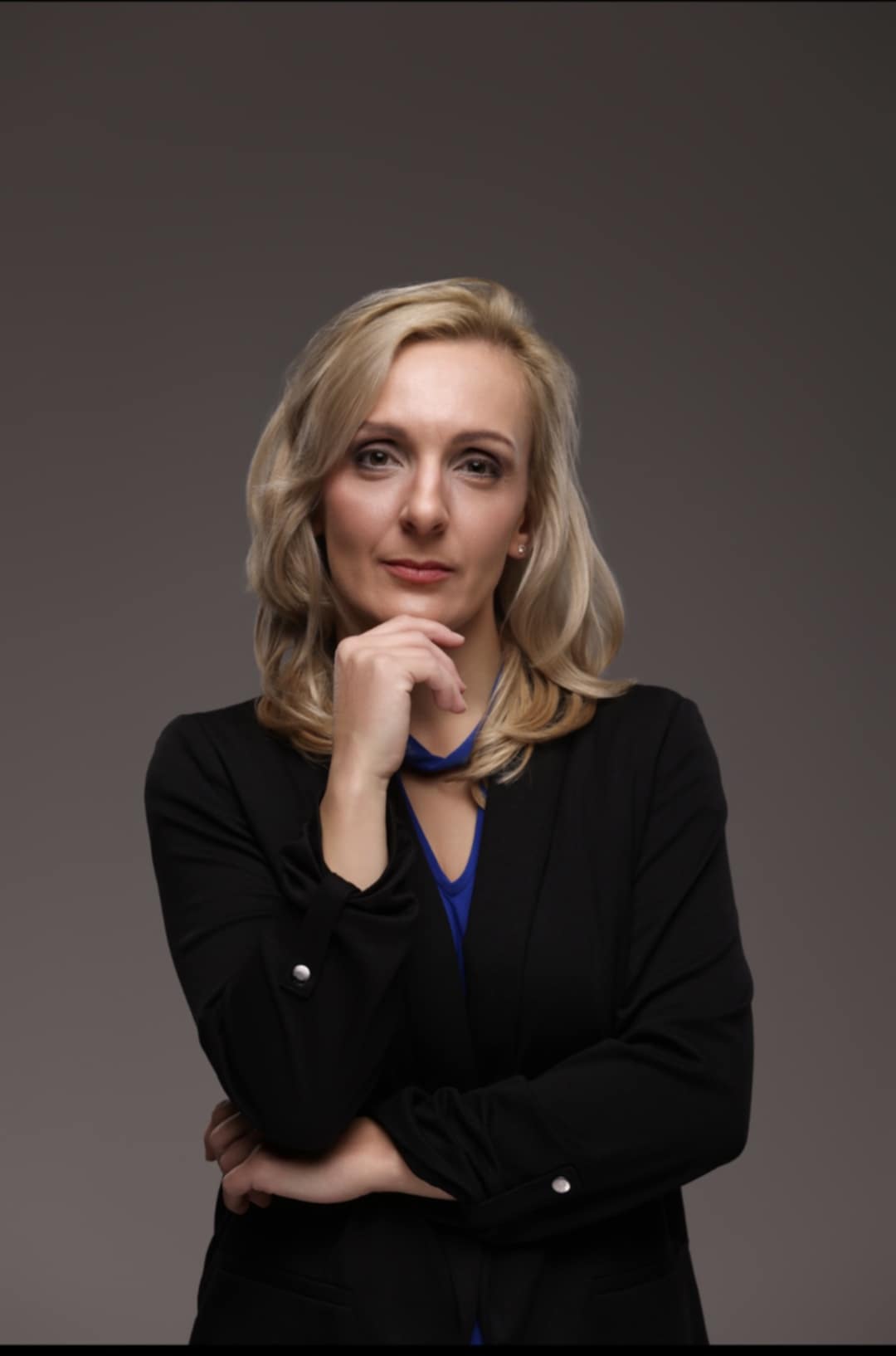 Lawyer posing thoughtfully with hand on chin against a neutral background