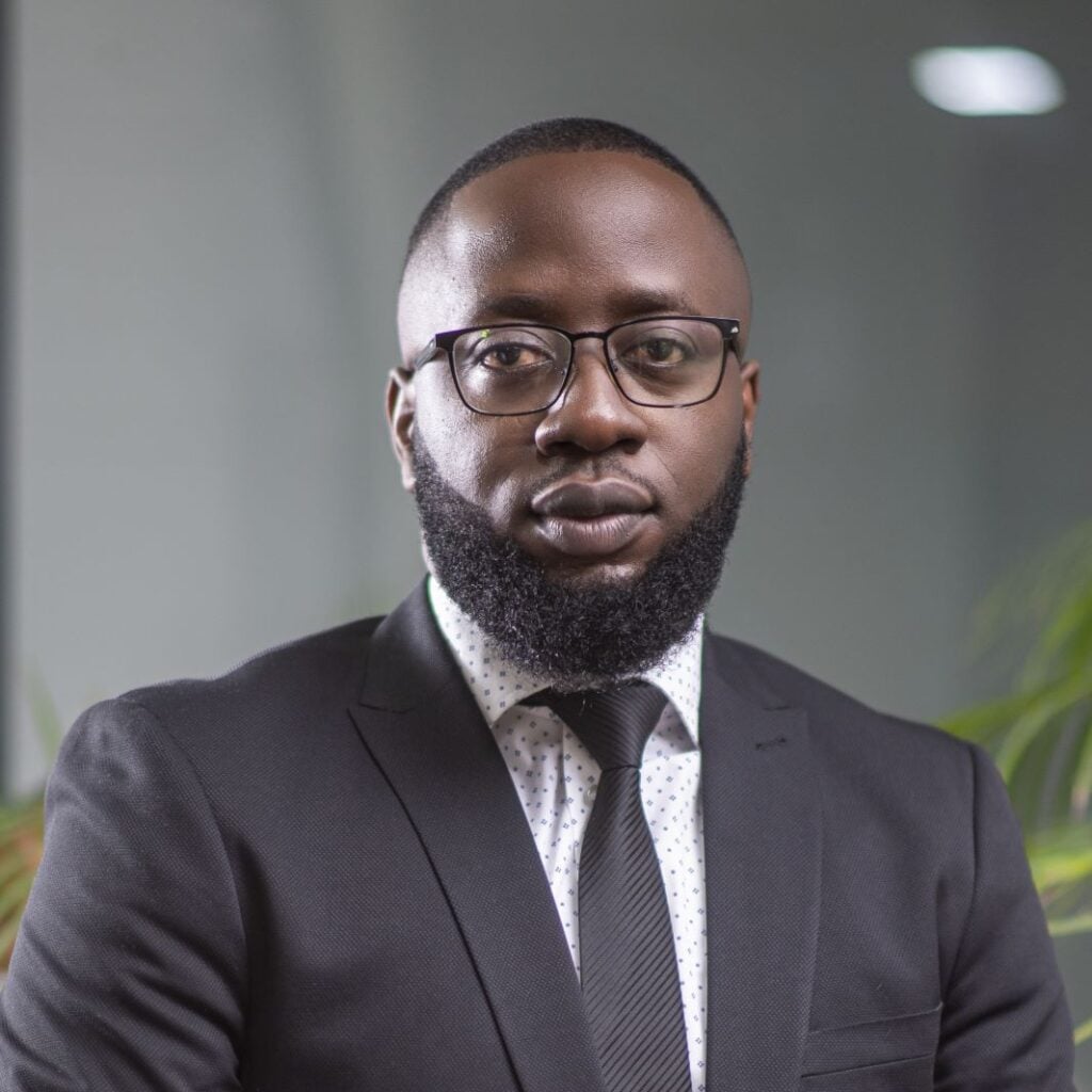 Lawyer in a suit with glasses, posing confidently in a modern office setting.