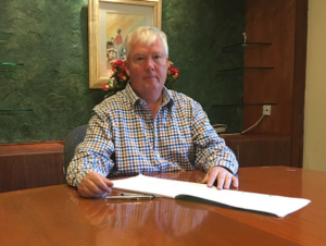 Lawyer seated at a desk with legal documents, in a professional office setting.