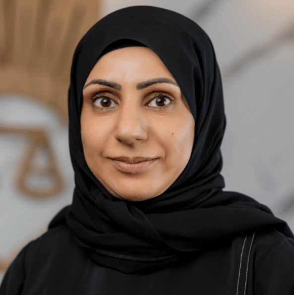 Attorney wearing a hijab, posing confidently in front of a legal-themed background with scales of justice.