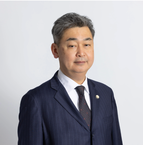 Attorney in a formal suit, posing against a plain background.