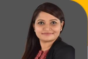 Attorney posing for a professional headshot with a neutral background, wearing a blazer and displaying a confident expression.