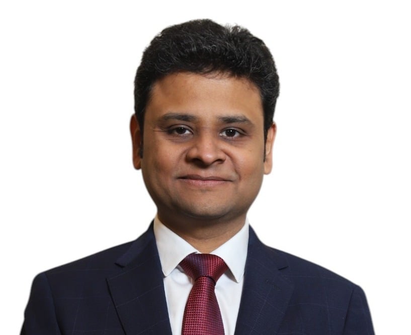 Lawyer in a suit with a confident expression, posed against a neutral background.