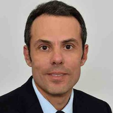 Male legal professional in a suit, presenting a confident expression against a plain background.
