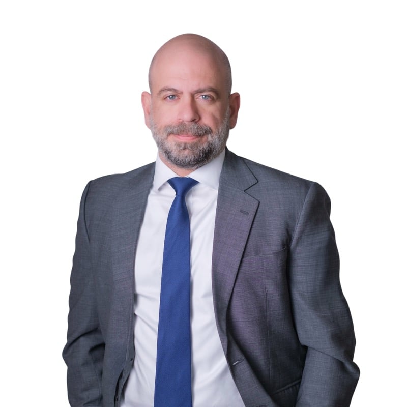 Lawyer in a gray suit and blue tie, posing against a plain background.