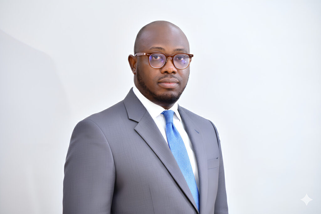 Lawyer in a formal suit and glasses, standing against a neutral background.