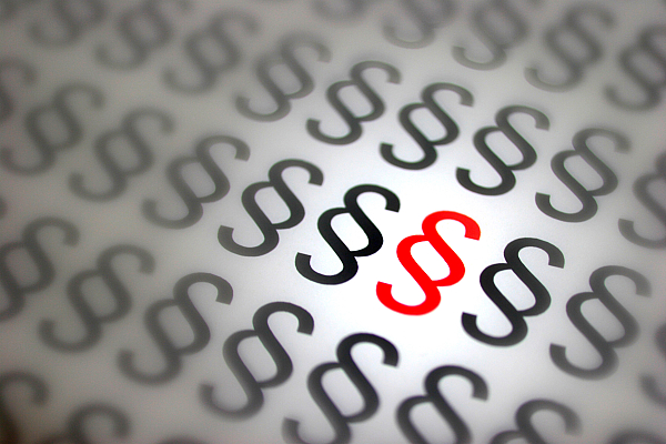 Red and gray legal symbols arranged in a pattern, highlighting a prominent red symbol in the center.