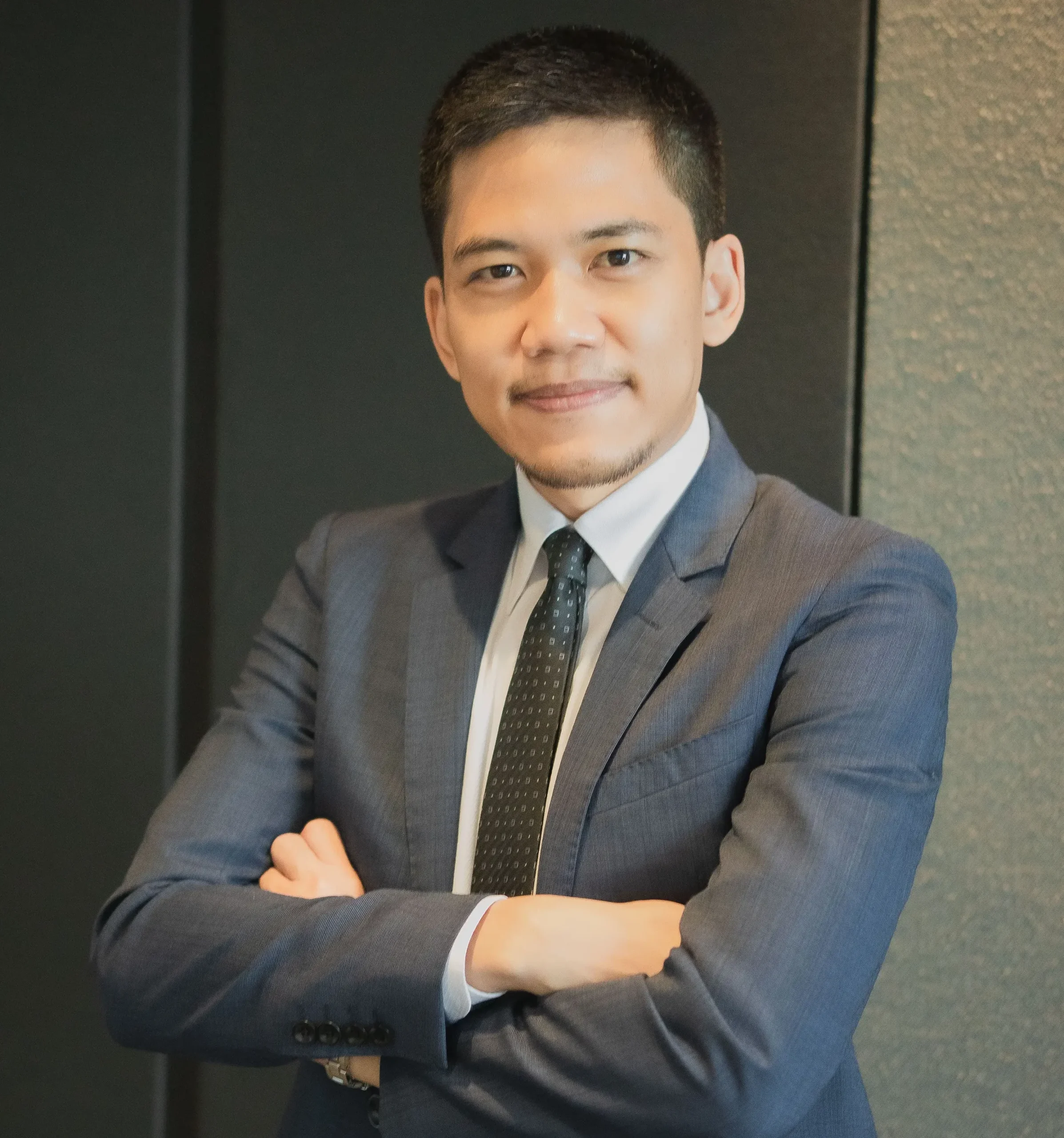 Lawyer posing confidently with arms crossed in a professional office setting.
