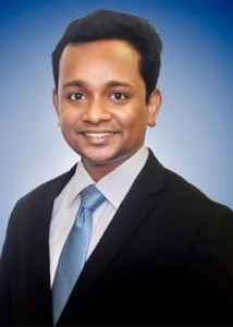 Attorney in a suit posing against a blue background, smiling confidently.