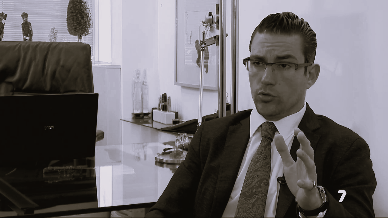 Attorney speaking while gesturing during a consultation in a modern law office.
