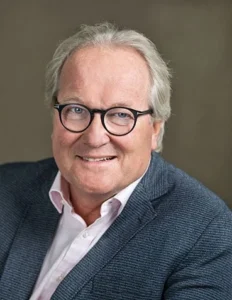 Experienced lawyer smiling and posing for a professional portrait against a neutral background.