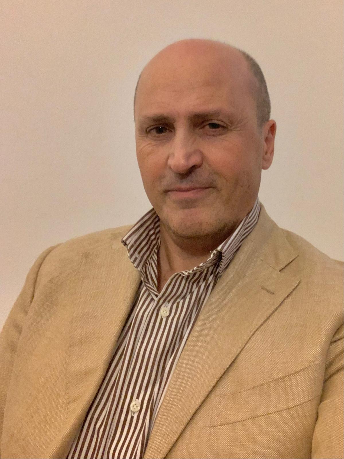 Lawyer posing in business attire, seated against a plain background.