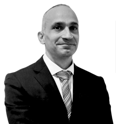 Attorney in a suit with a confident expression, posing against a plain background.