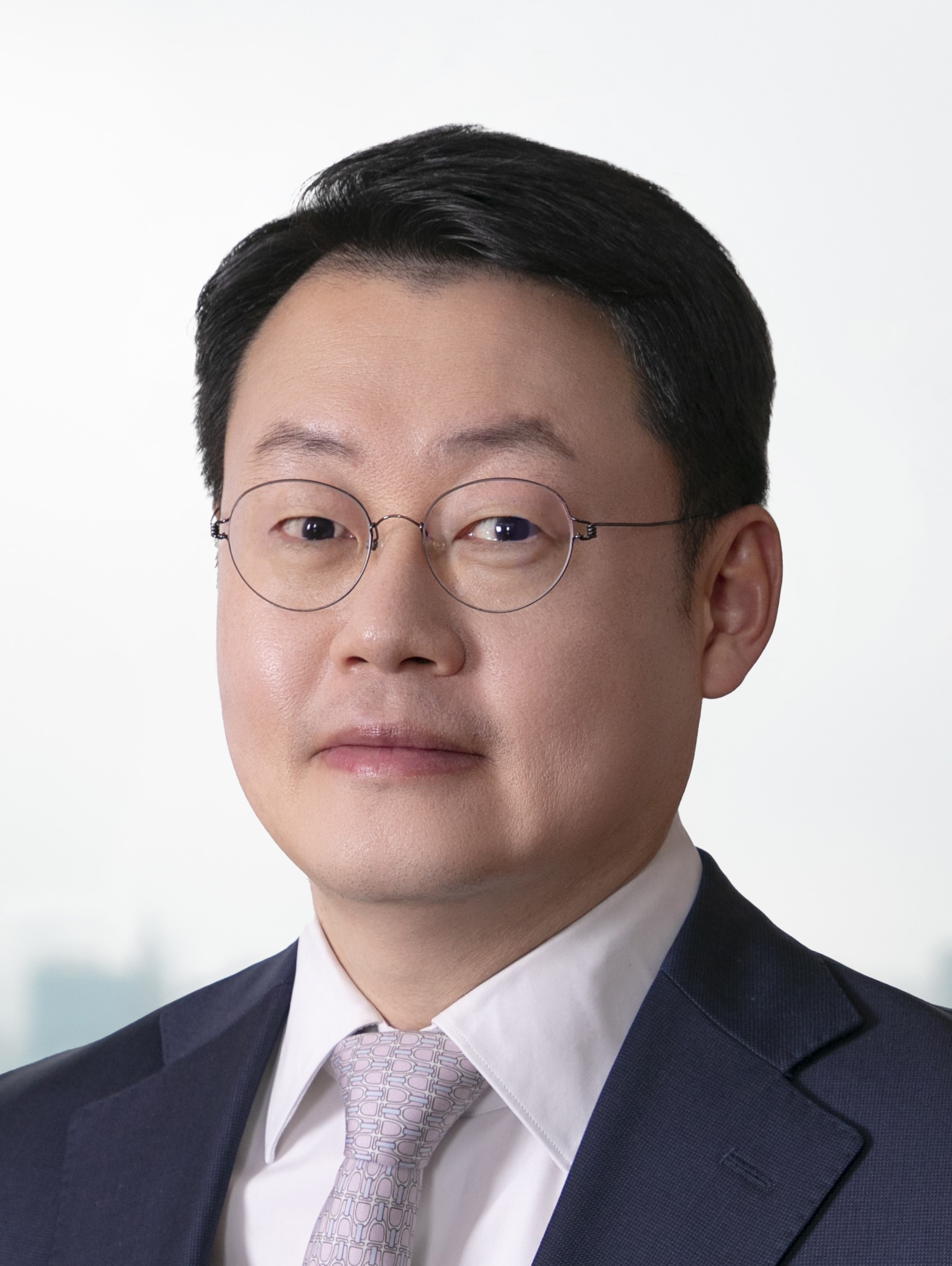 Lawyer in professional attire posing for a portrait with a neutral background.