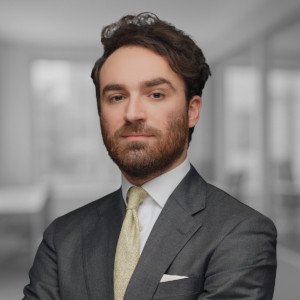 Lawyer in a suit with arms crossed, positioned in a modern law office setting.
