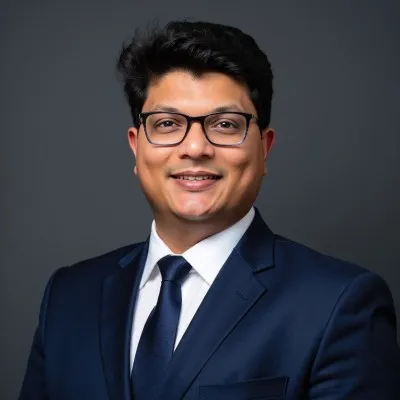Lawyer in business attire smiling against a neutral background.