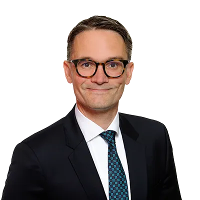 Attorney posing for professional headshot, wearing a suit and tie, with a neutral expression.