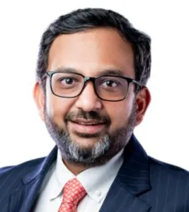 Professional in a suit with glasses, smiling, suitable for a legal or consulting profile.