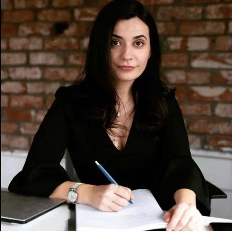 Lawyer writing notes and reviewing documents at a desk in a professional office setting.