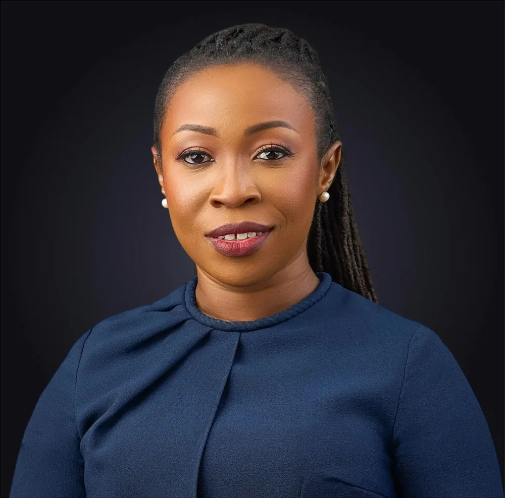 Legal professional with a professional attire, smiling against a dark background.