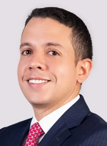 Professional-looking man in a suit with a friendly smile, possibly a lawyer or legal professional, set against a neutral background.