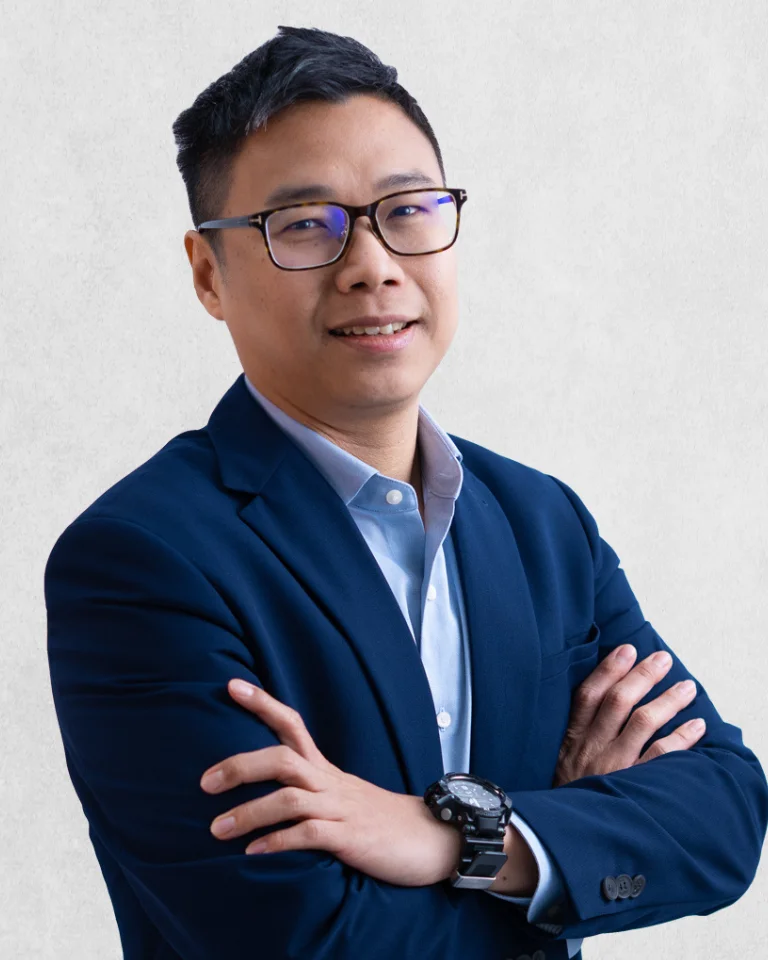 Lawyer in a blue suit, standing confidently with crossed arms against a neutral background.