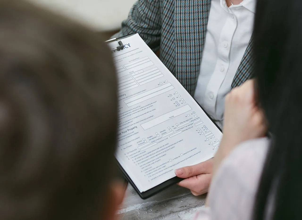 Attorney discussing legal forms with clients at a desk.