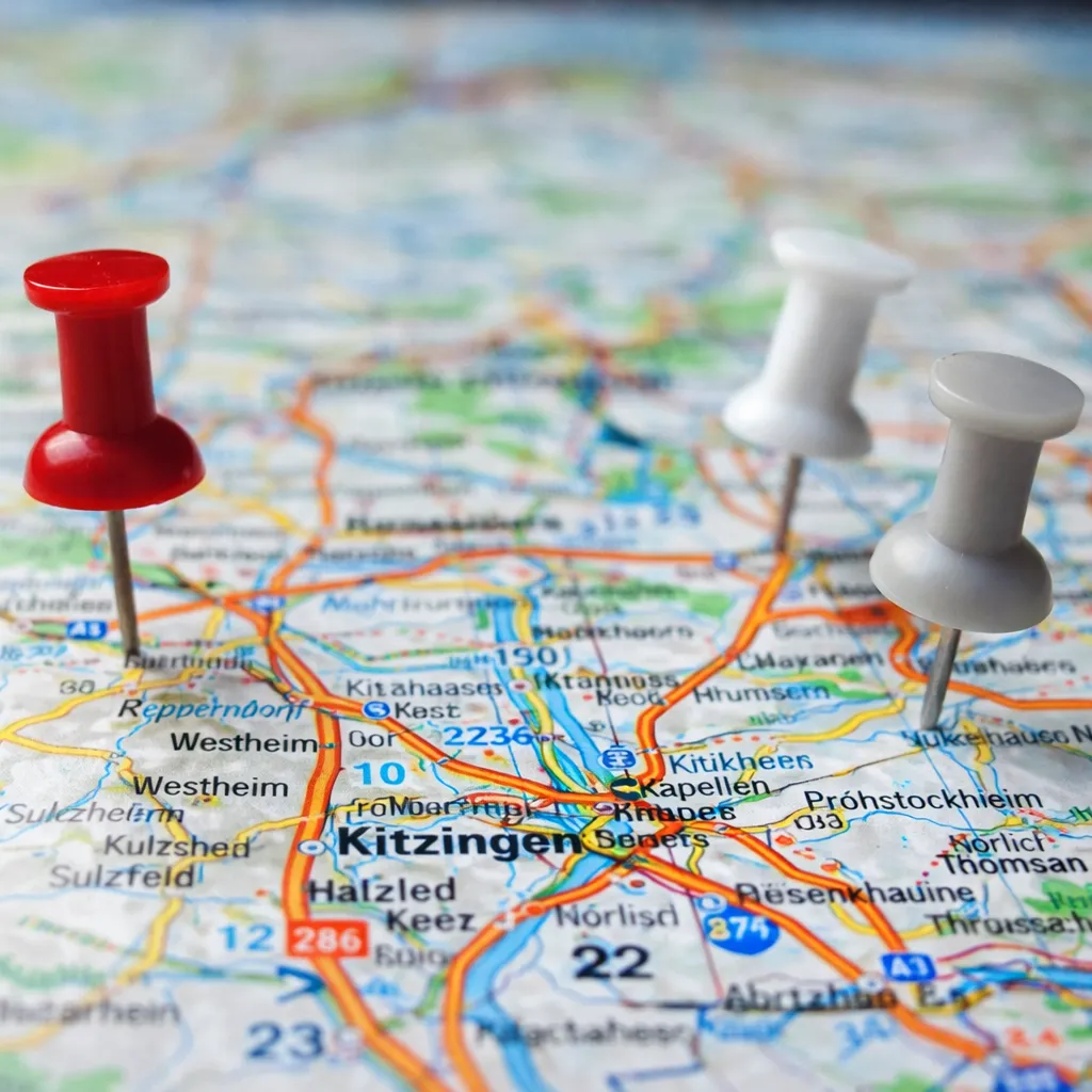 Red and white pins marking locations on a detailed road map featuring towns and highways.