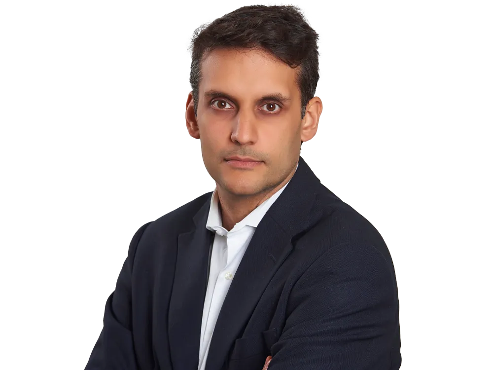 Lawyer in a suit with arms crossed, appearing confident and professional.