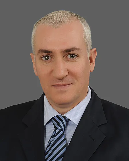 Lawyer in a suit with a striped tie, posed against a neutral background.